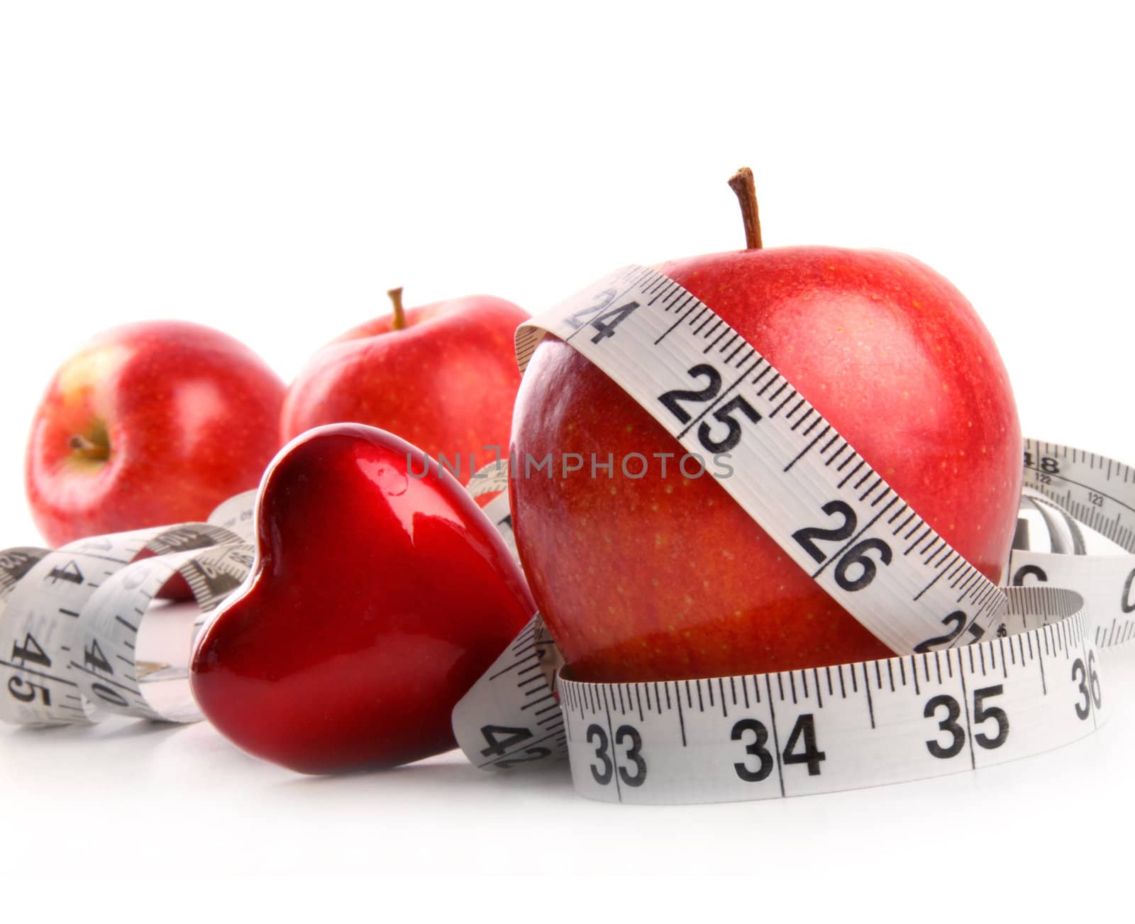 Red apples,heart and measuring tape on white  by Sandralise