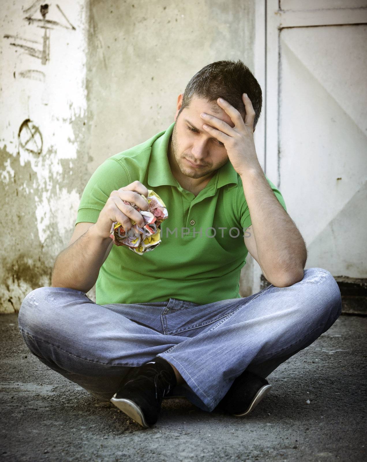 Depressed young man sitting on concrete