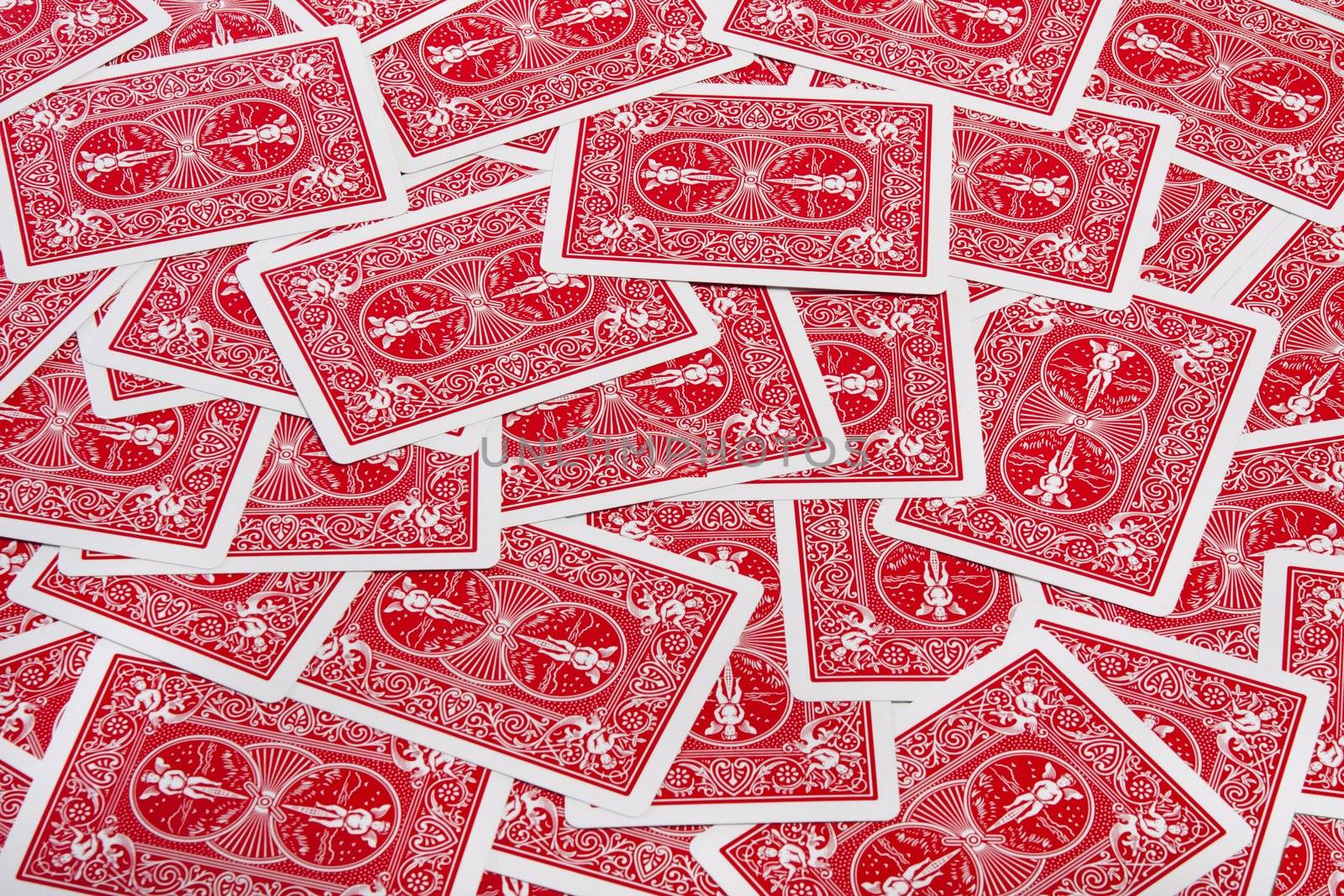 Close up view of a bunch of flipped playing cards spread on a green cloth table.