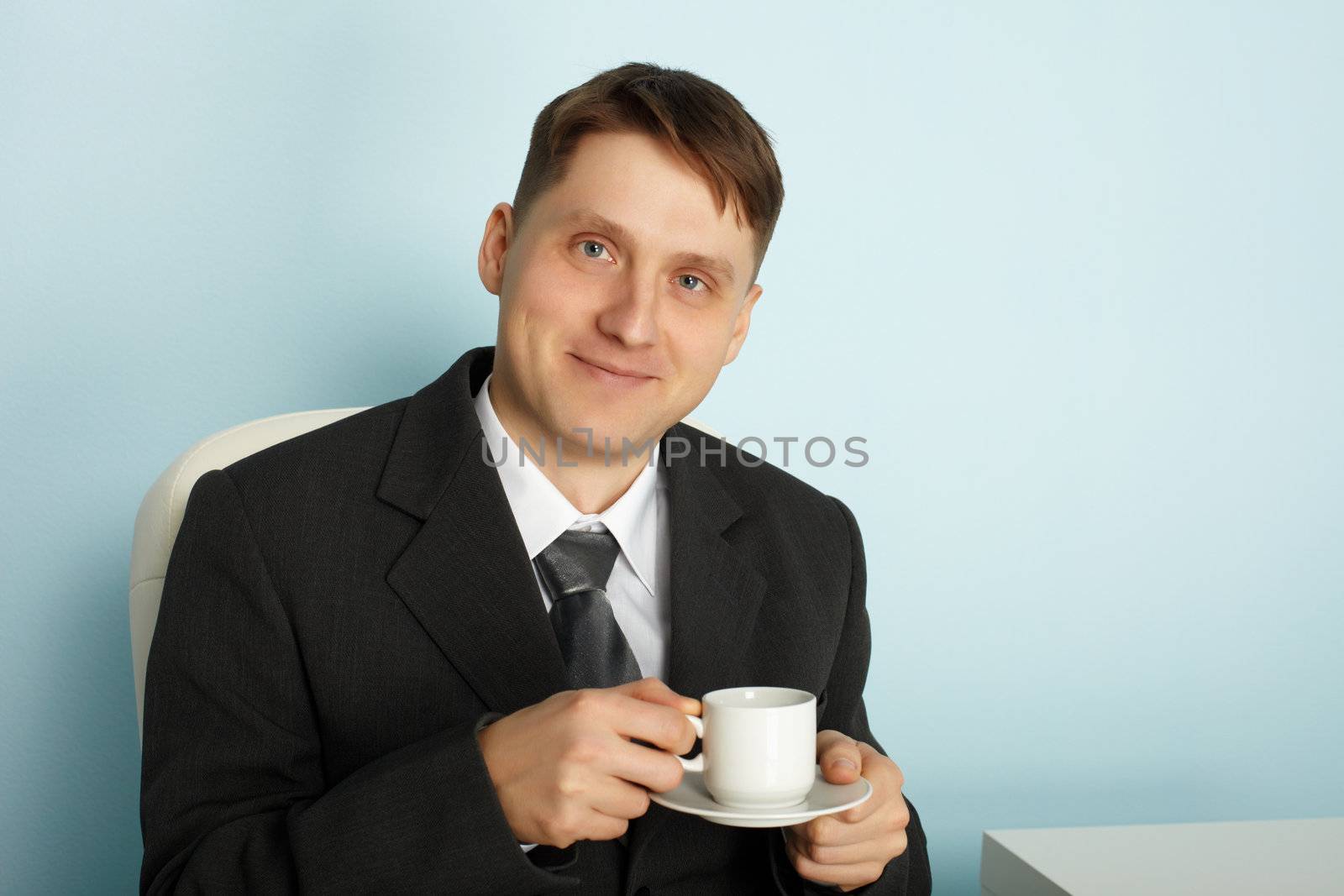 Handsome young businessman drinking coffee in the break time