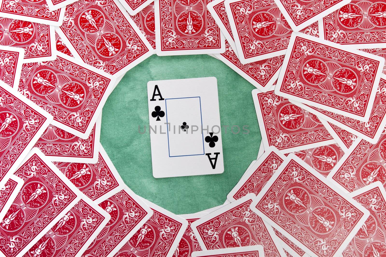 Close up view of a bunch of flipped playing cards spread on a green cloth table.