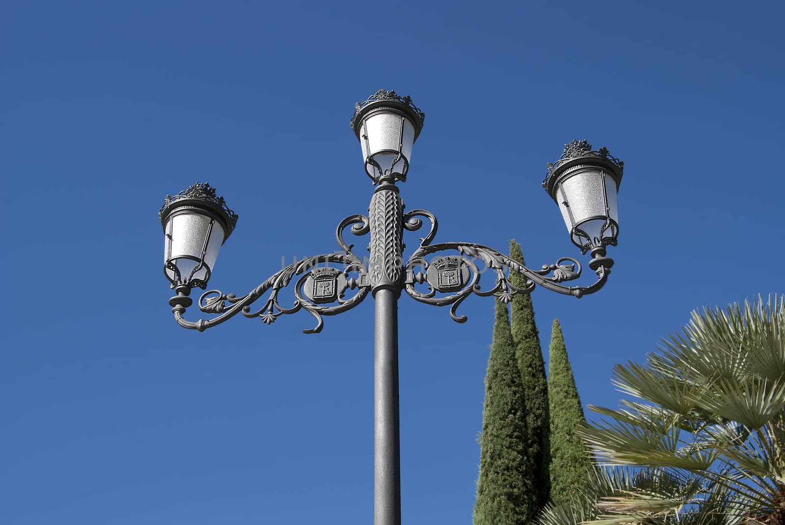 Antique vintage lamp iron curls against the blue sky