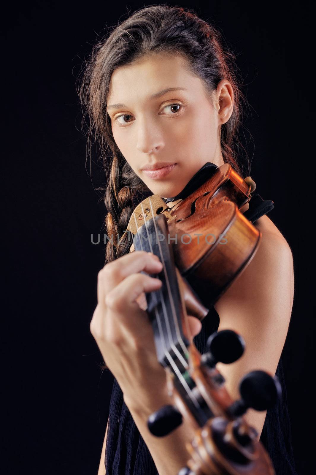 Young woman holding a violin. Isolated on the black background