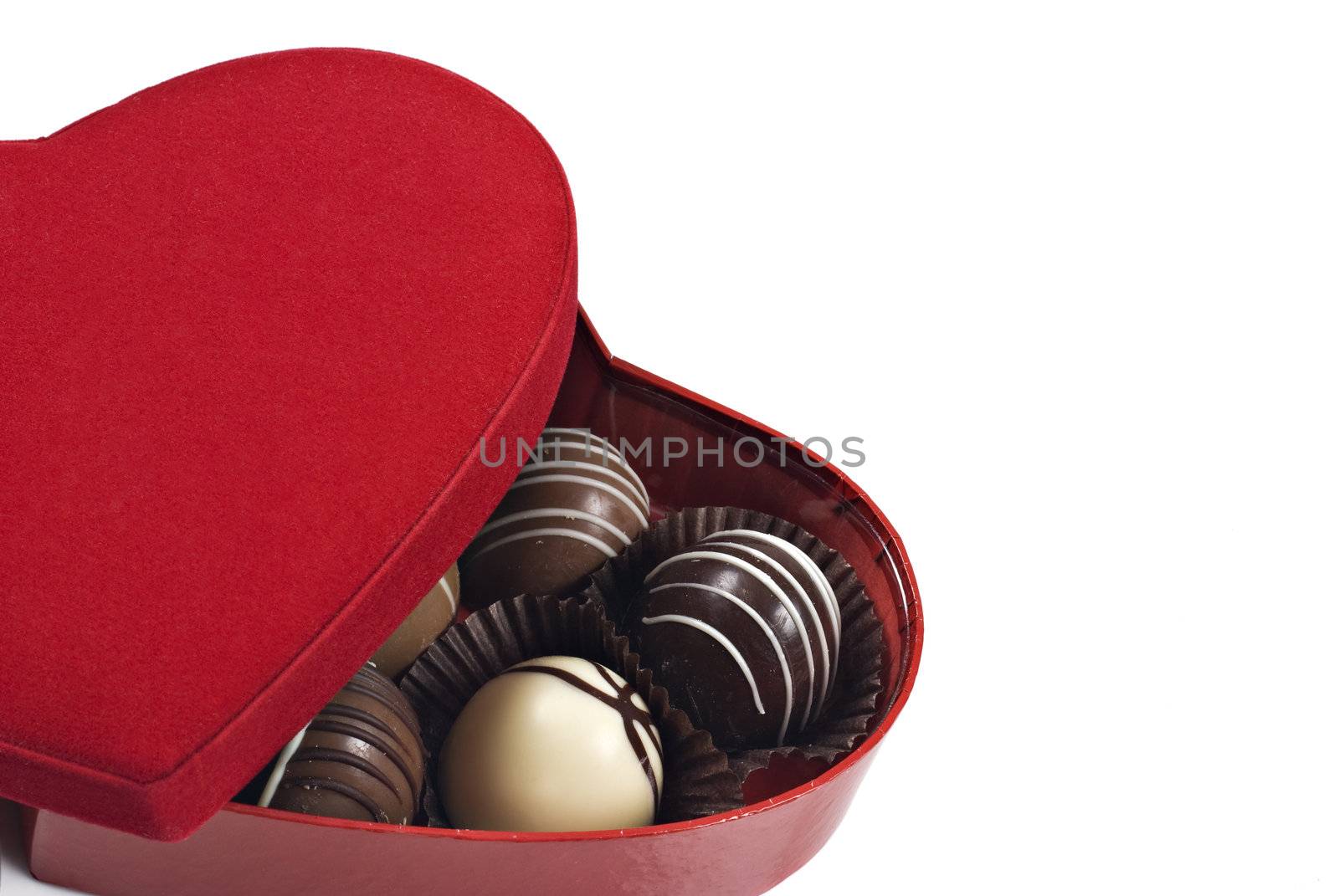 a Red heart shaped box of chocolates on a white background with space for text by tish1