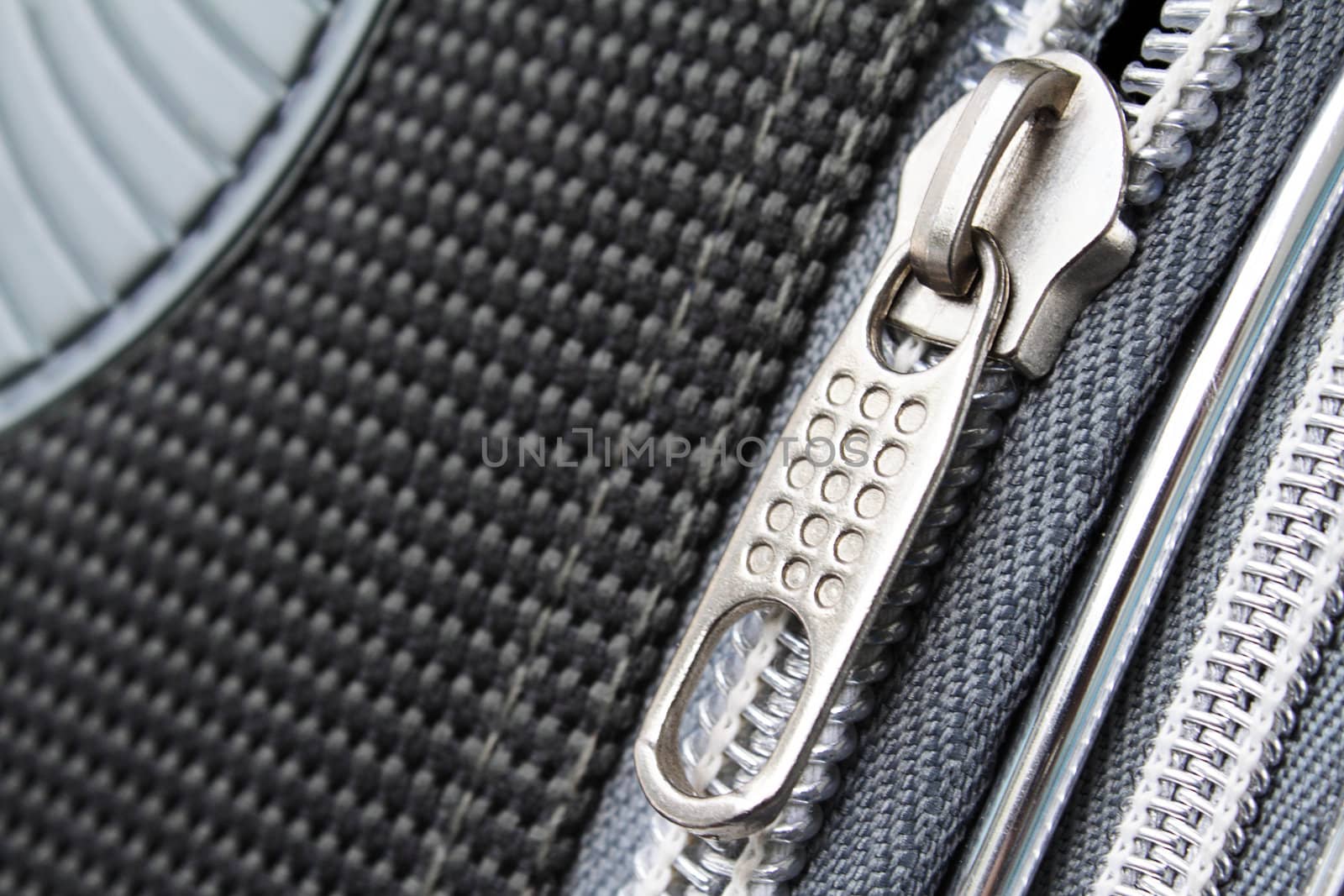 A zipper on the grayish suitcase closeup photo