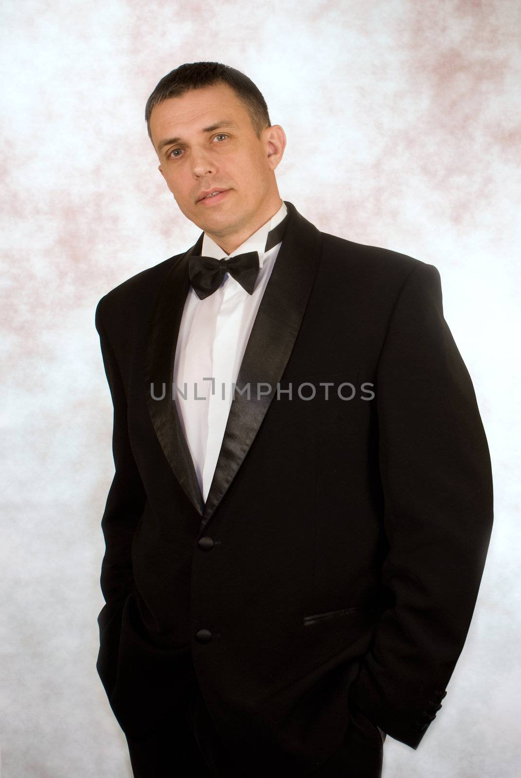 Portrait the man in a classical smocking on an abstract background