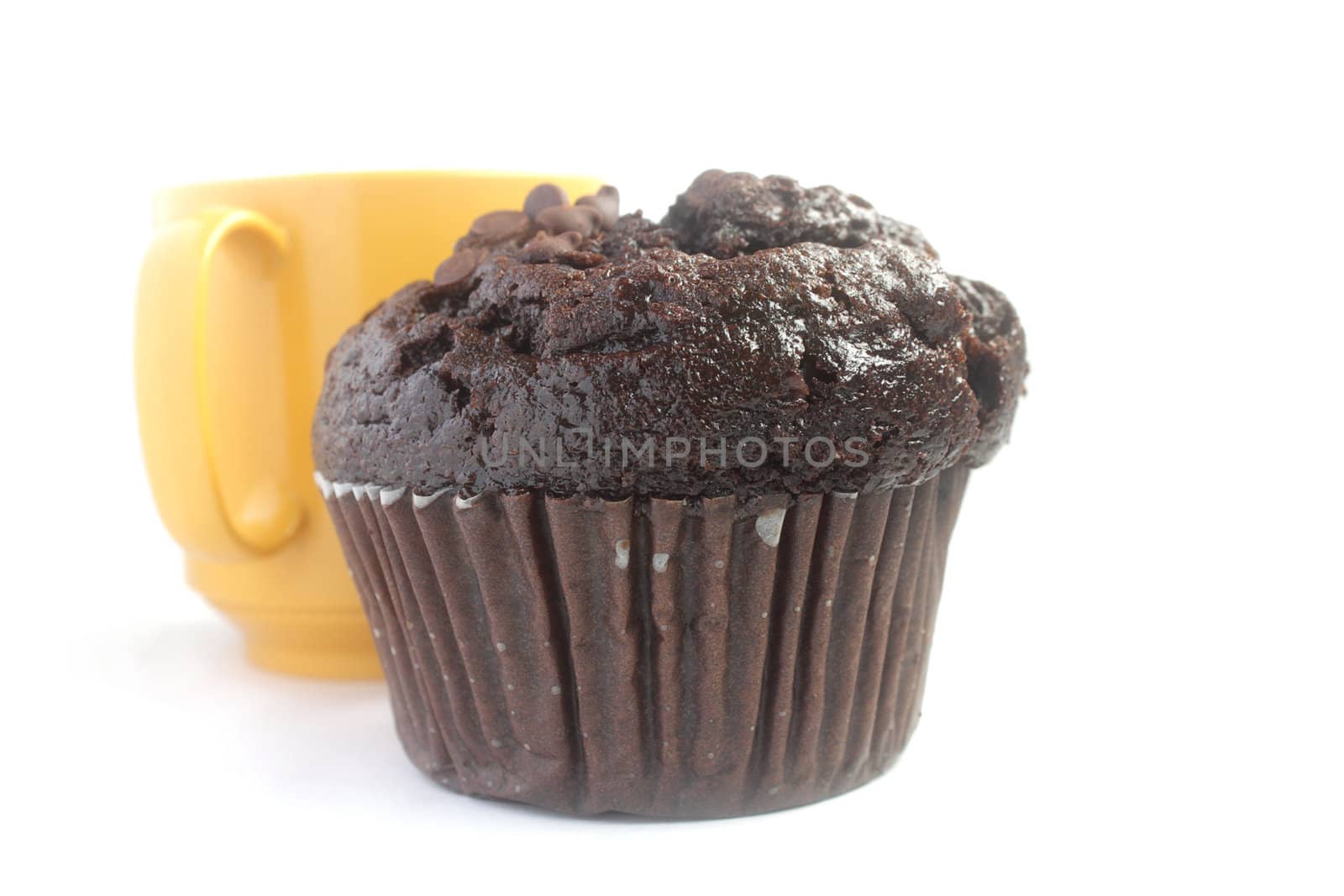 Chocolate muffin and a yellow cup of tea isolated on white background