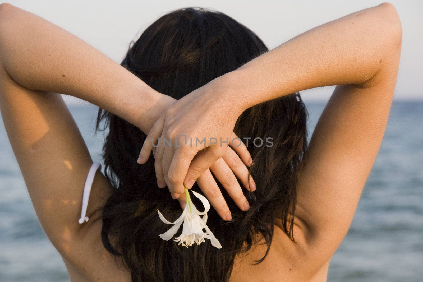 young woman with flower enjoys the sea.