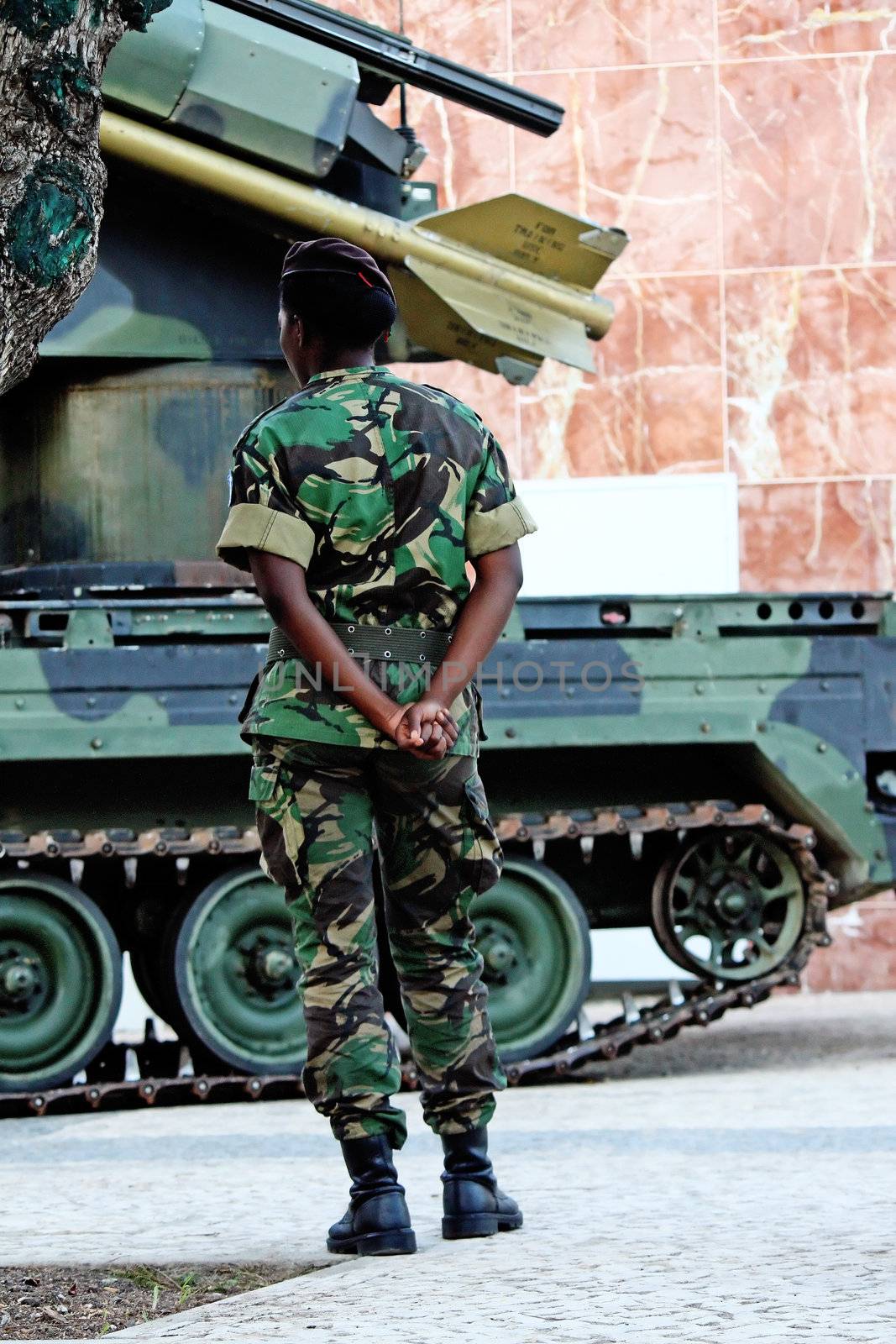 Black soldier woman standing next to an armored missile vehicle.