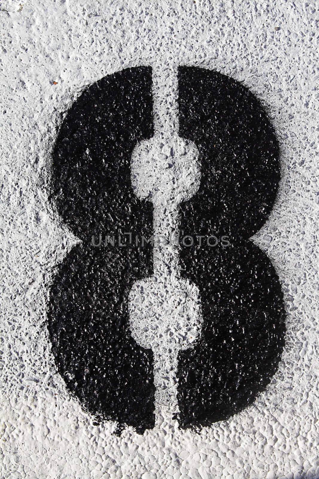 Black number eight painted on the asphalt
