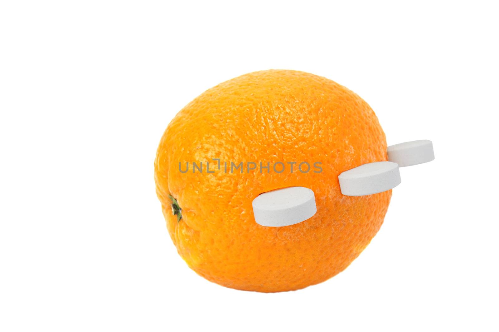 Ripe orange with white round tablets of vitamin C isolated on white background