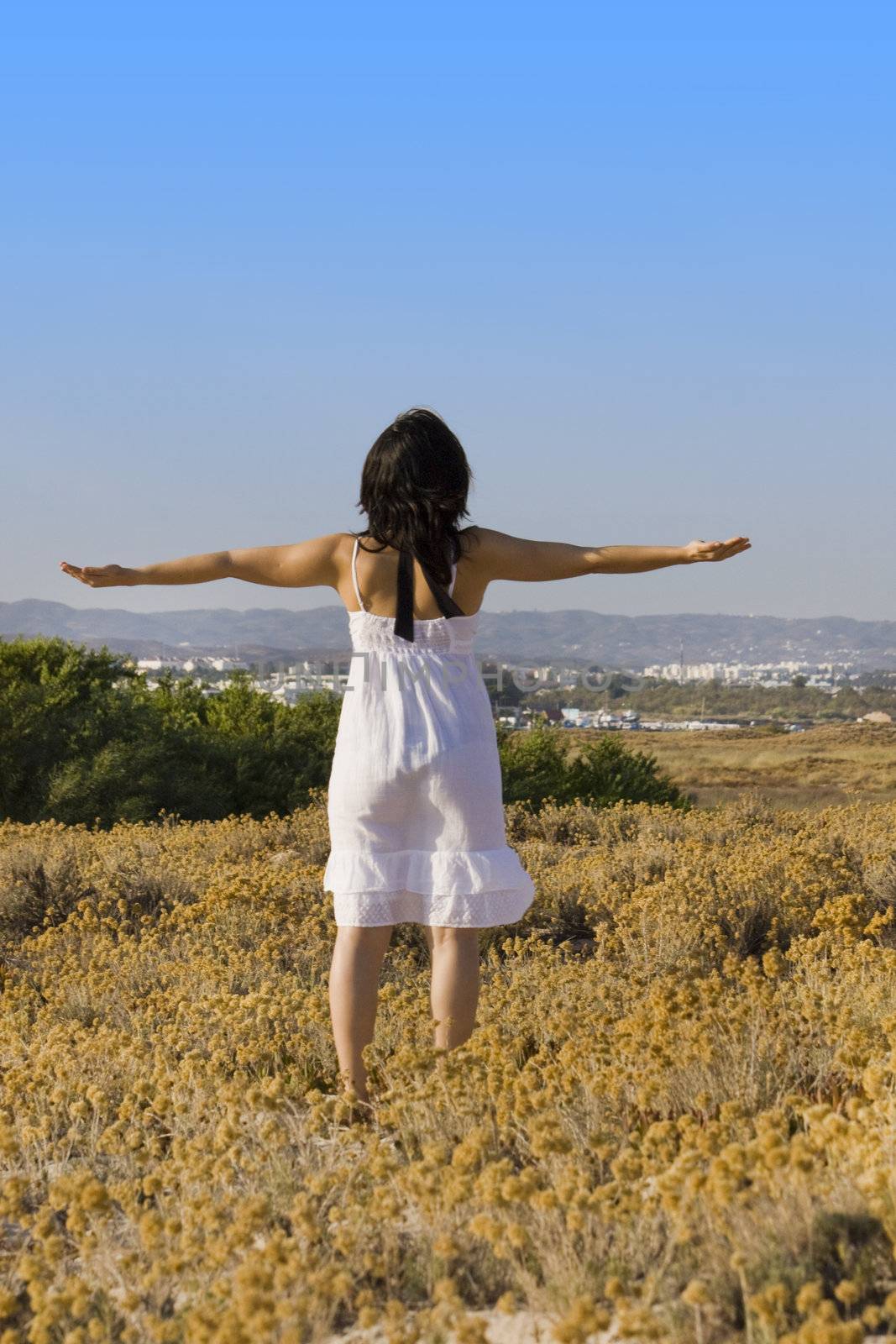 Young woman with white dress practicing yoga.