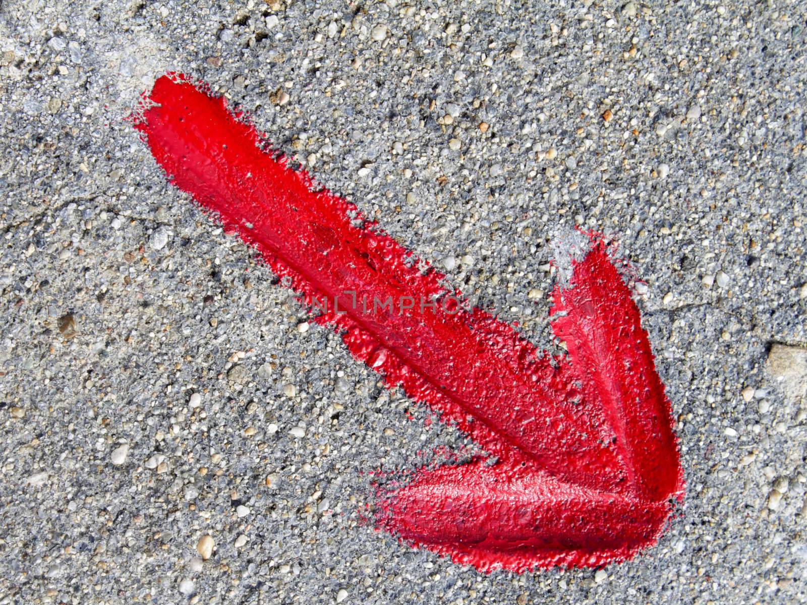 Red arrow pointing to the lower right corner, painted on asphalt