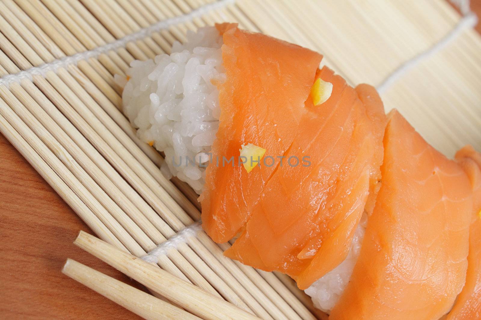 Salmon sushi and chopsticks on bamboo mat by pulen