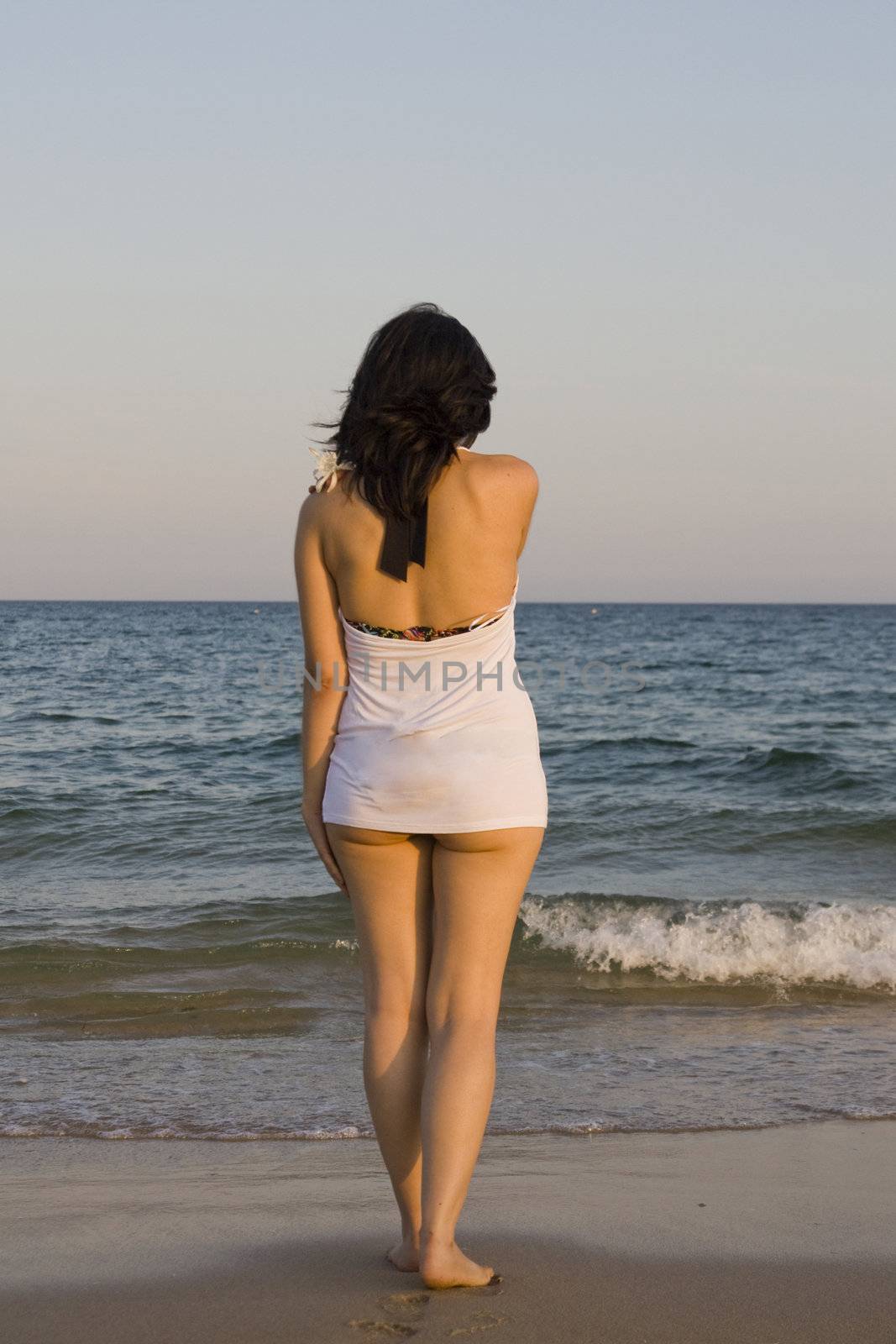 young woman with flower enjoys the sea.