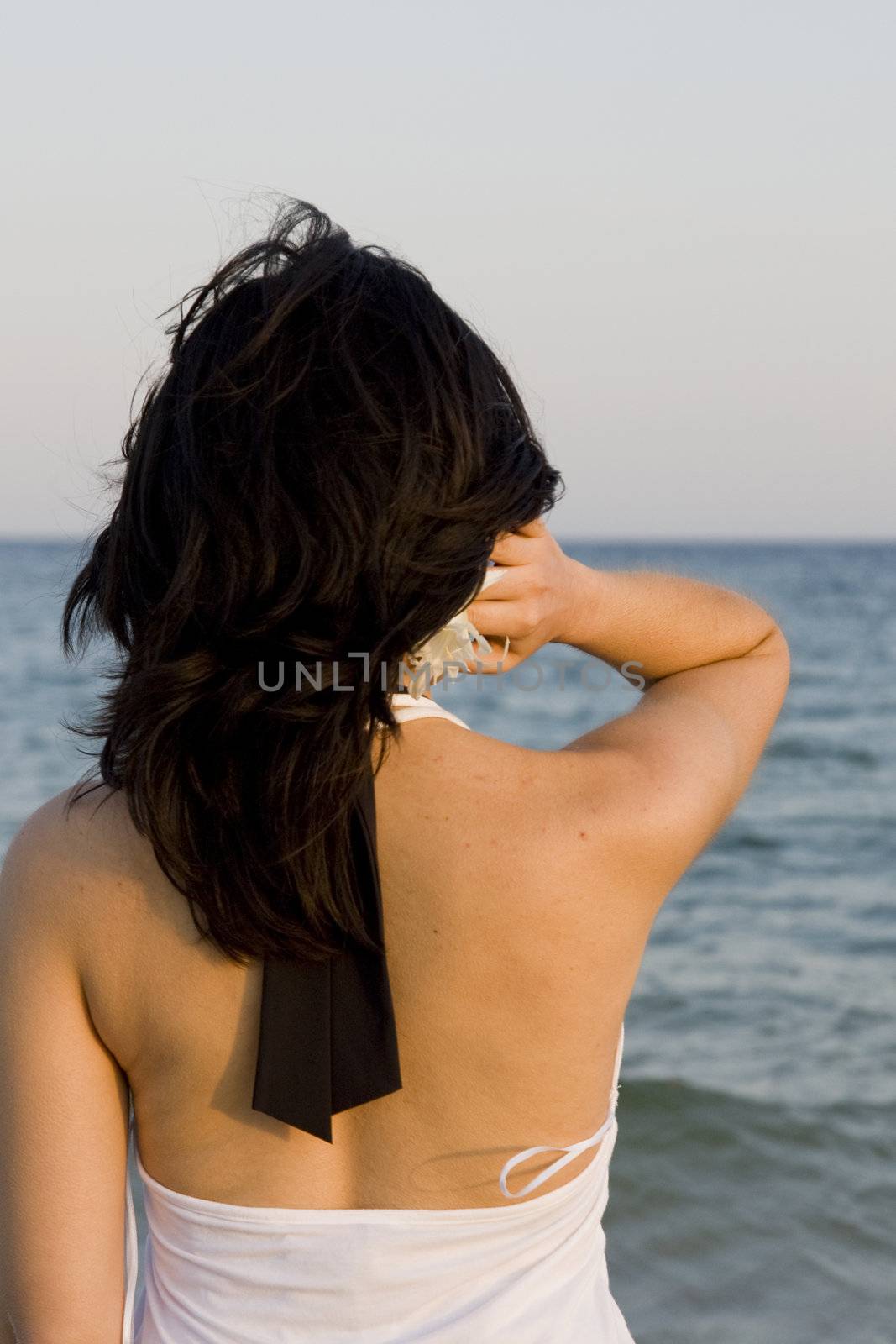 young woman with flower enjoys the sea.