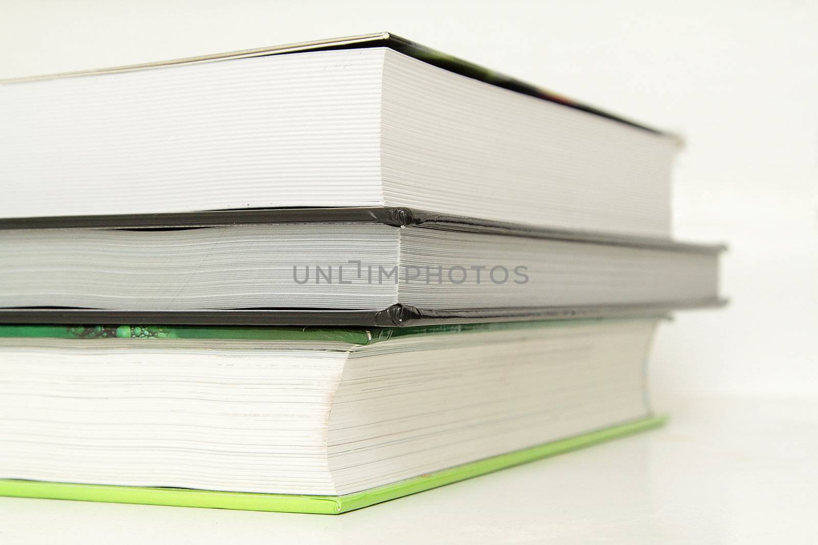 A stack of three books, closeup photo