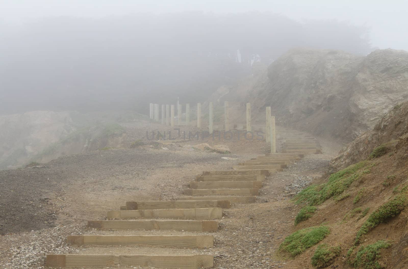 Wooden stairs among rocks in foggy day