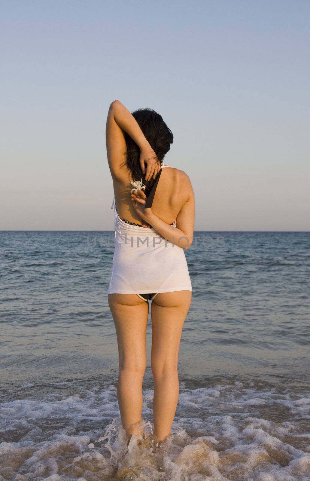 young woman with flower enjoys the sea.