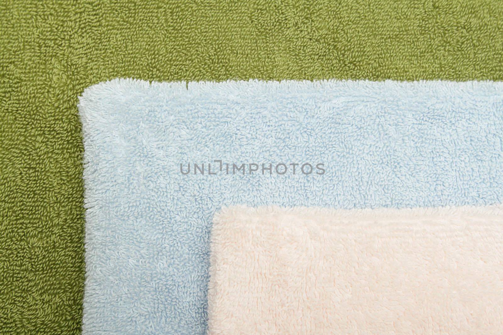 Closeup photo of three bath towels of differen colors