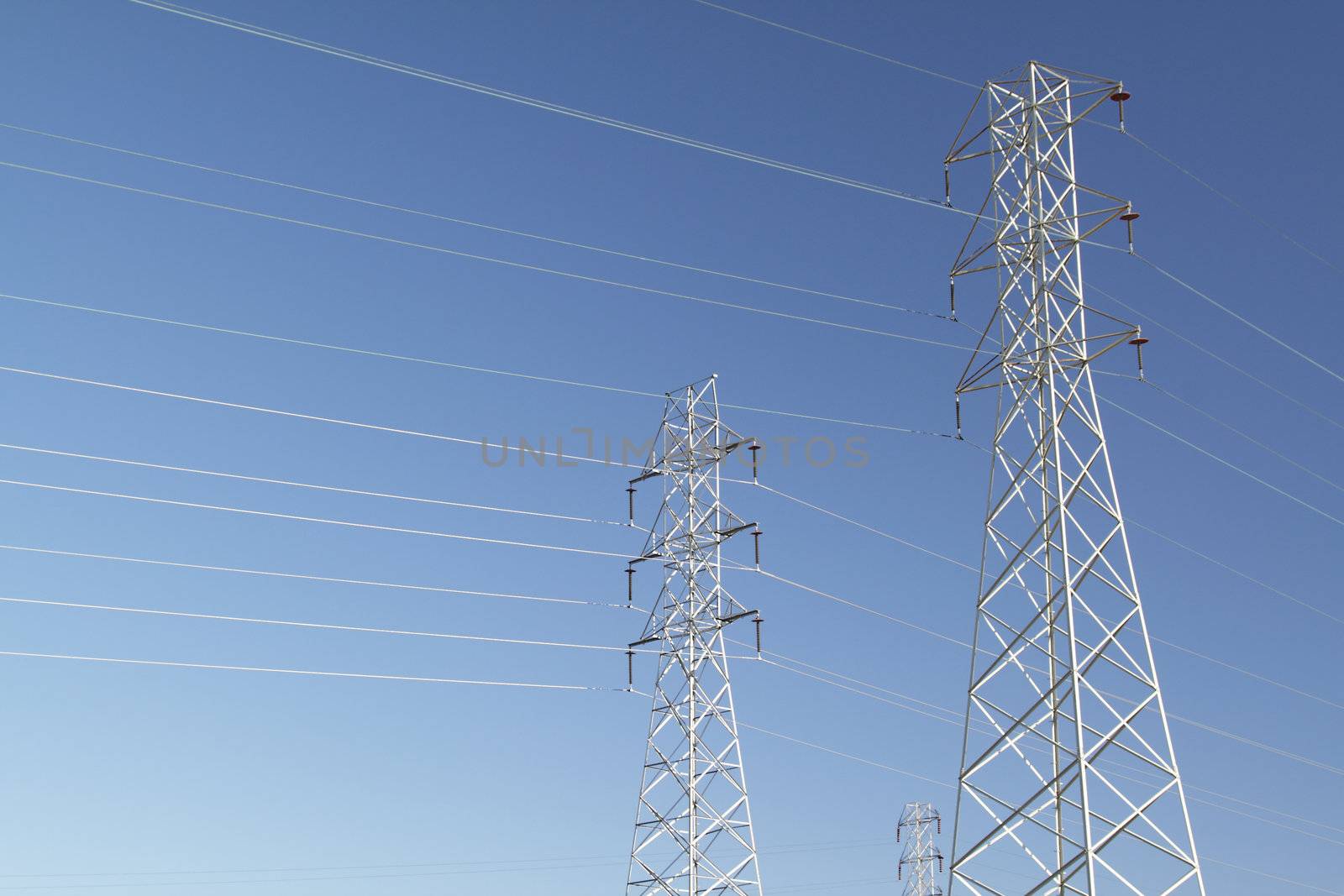 High voltage power lines over blue sky