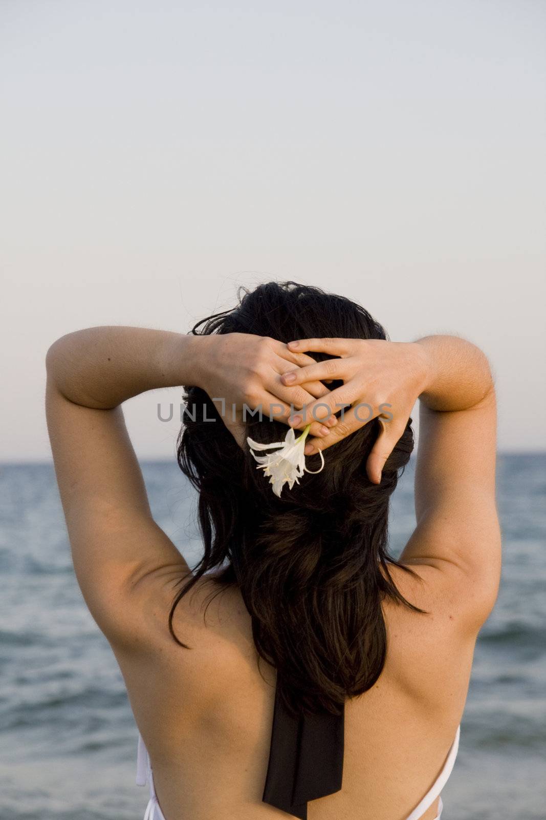 young woman with flower enjoys the sea.