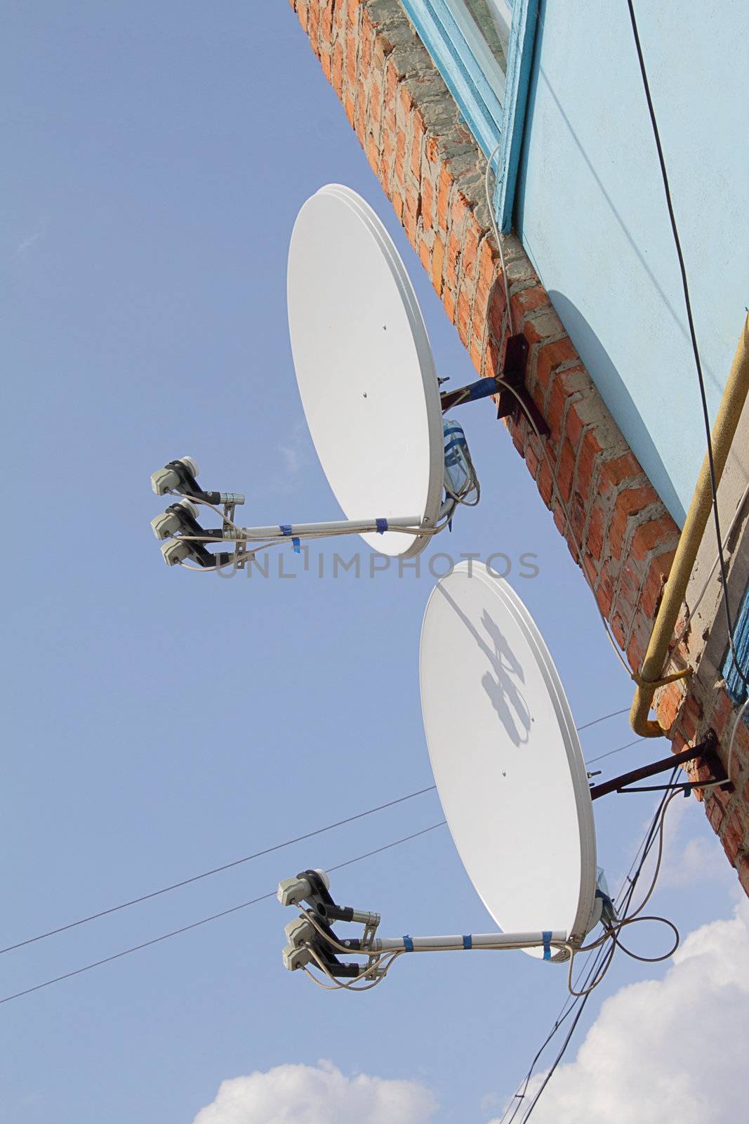 Two satellite dishes on the apartment house wall