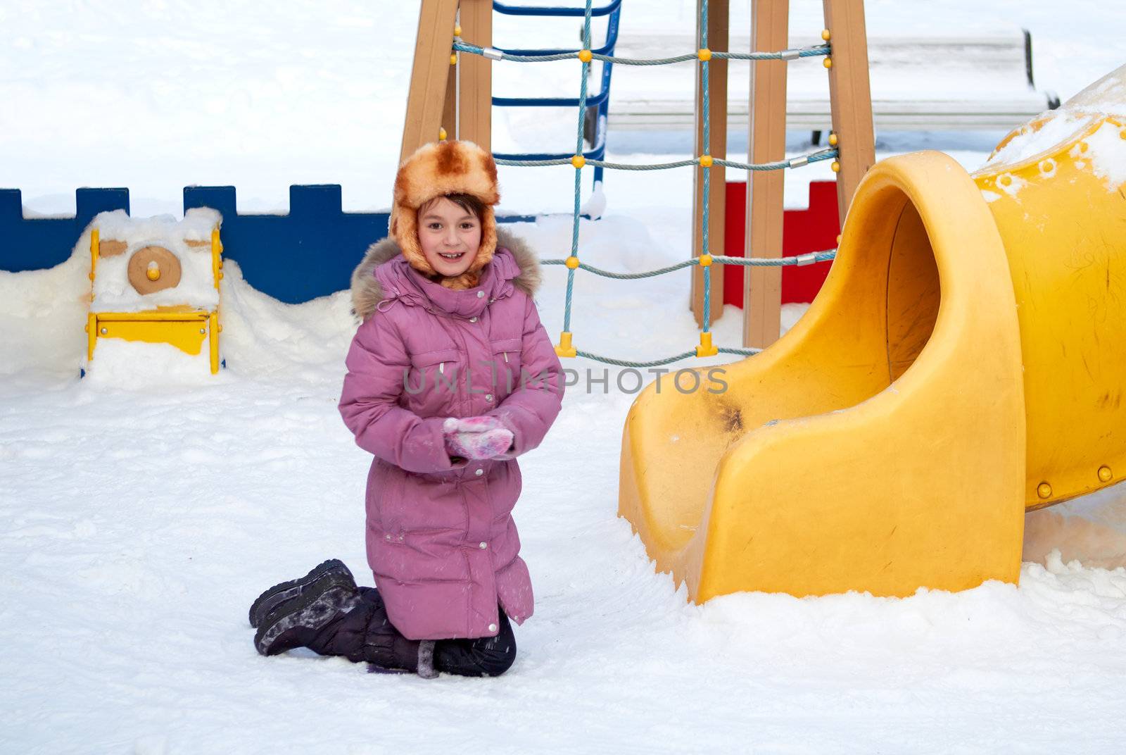 The girl at a childrens play area in winter