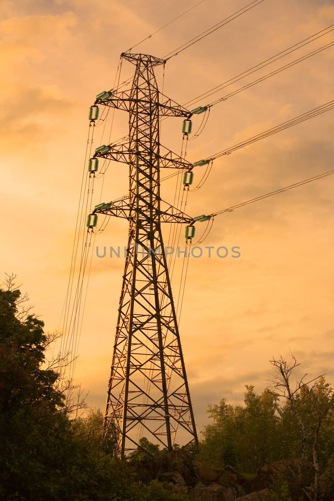 Electricity pylon with clouds and trees in the backround