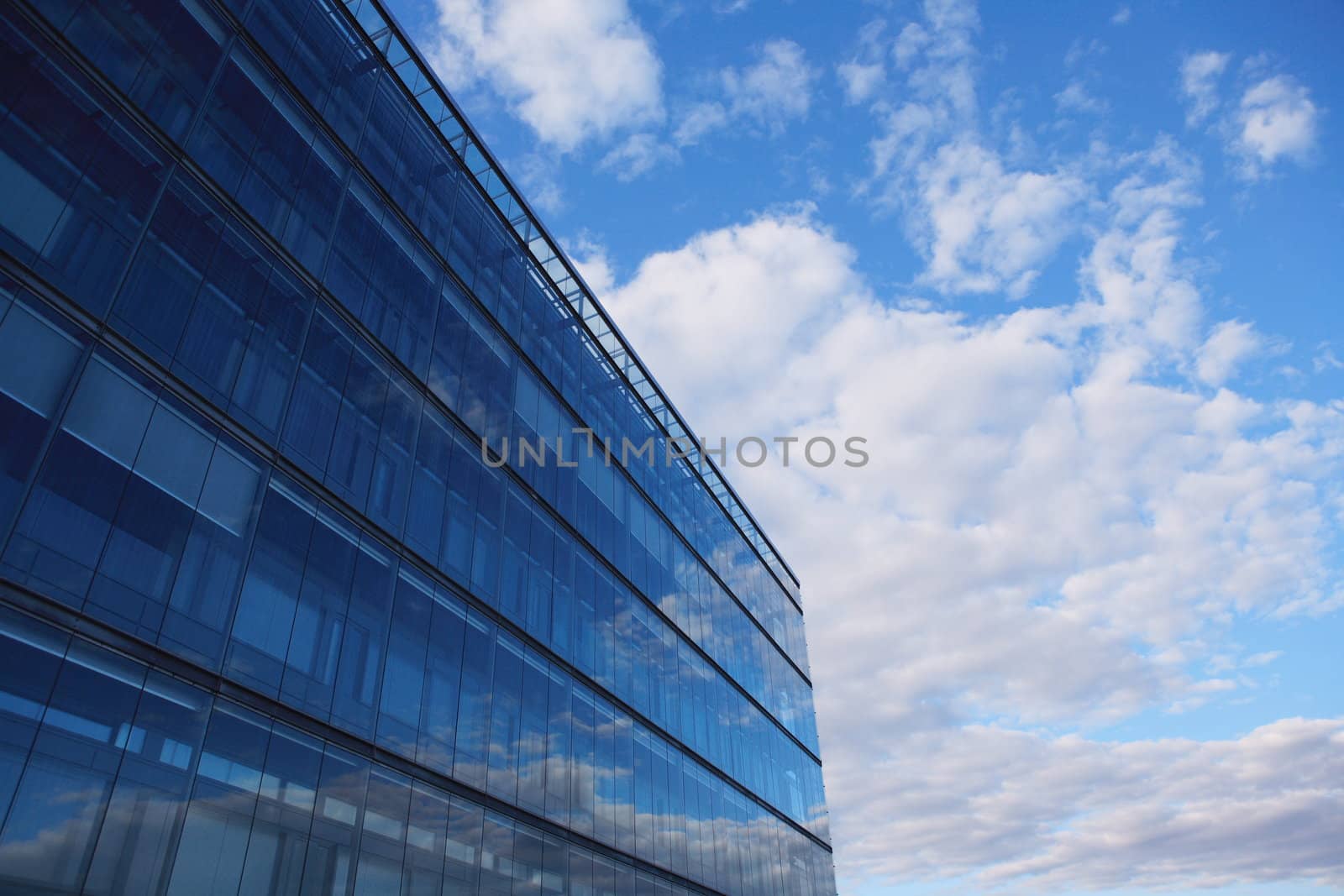 Sky and glass wall of an office building, reflections of clouds