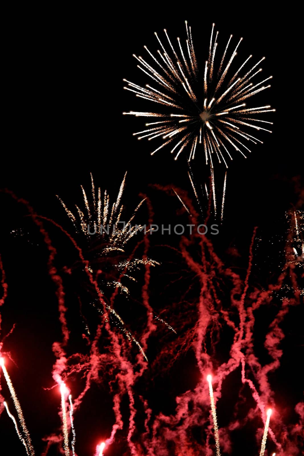 Red and white fireworks flares, over black