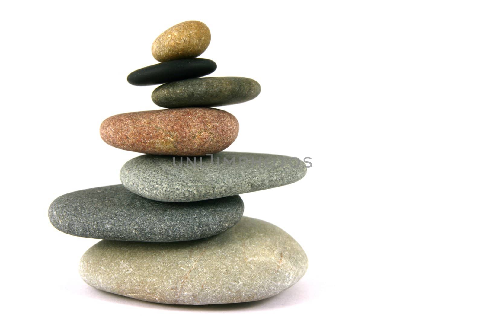 Seven pebbles pyramid in staggered rows, over white