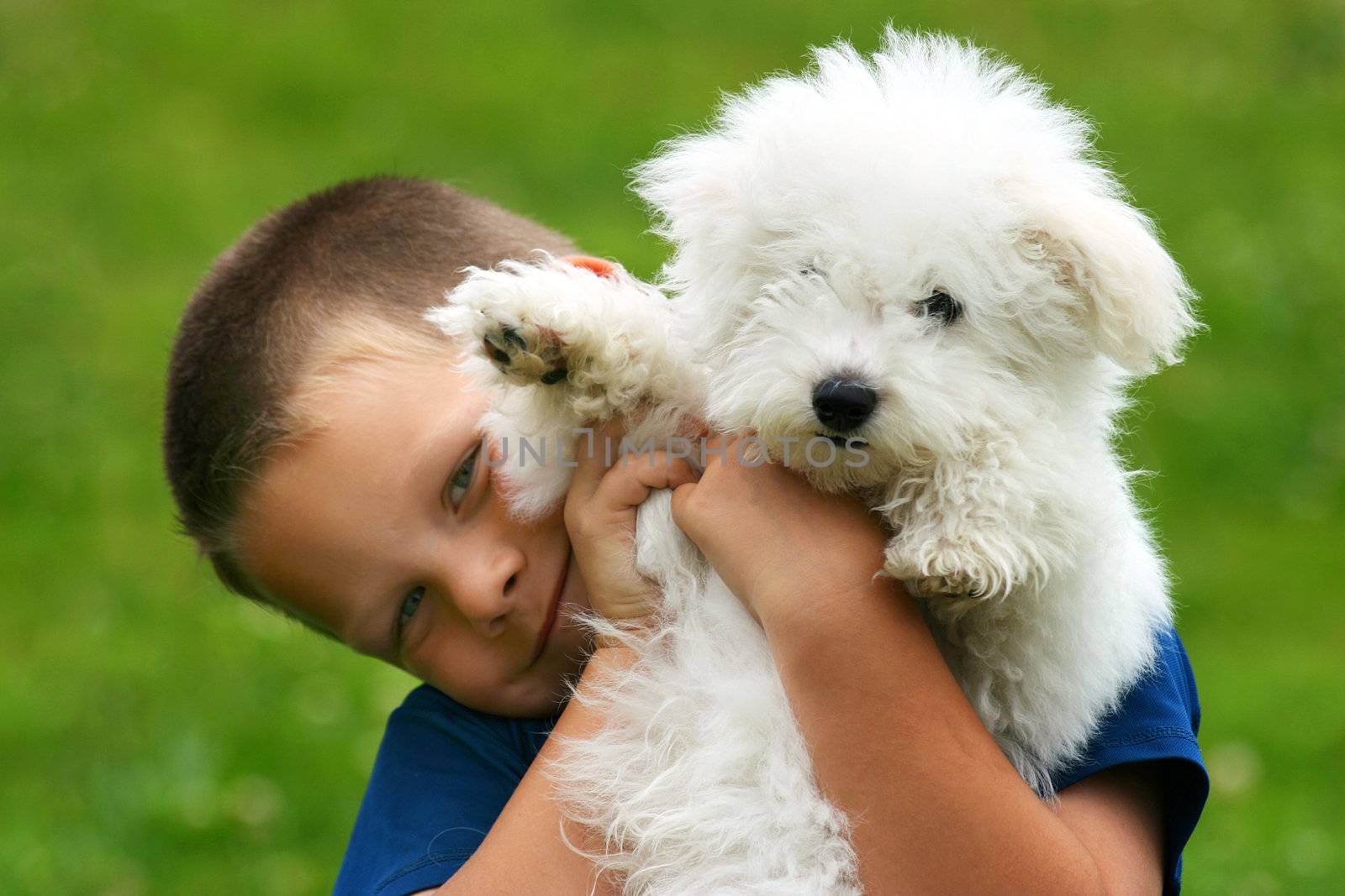 Happy boy bearing a puppy in his arms