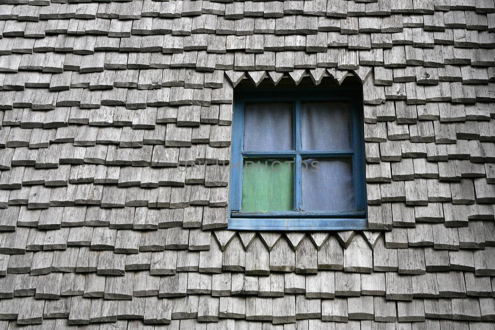 Colored window on a ancient wooden roof