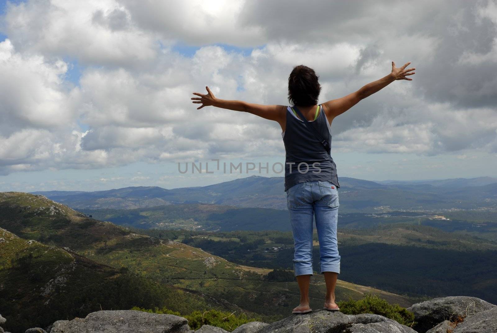 woman with arms wide open in the mountain