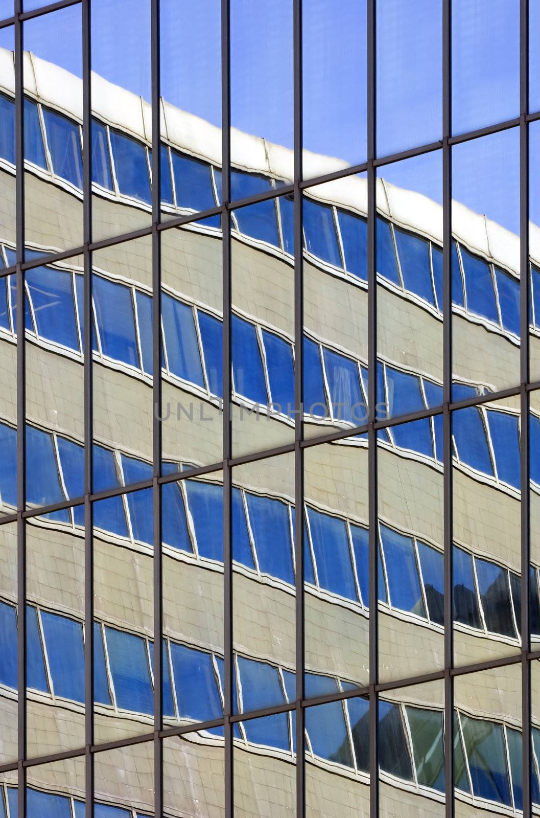 sky and building reflected in the glasses of another building