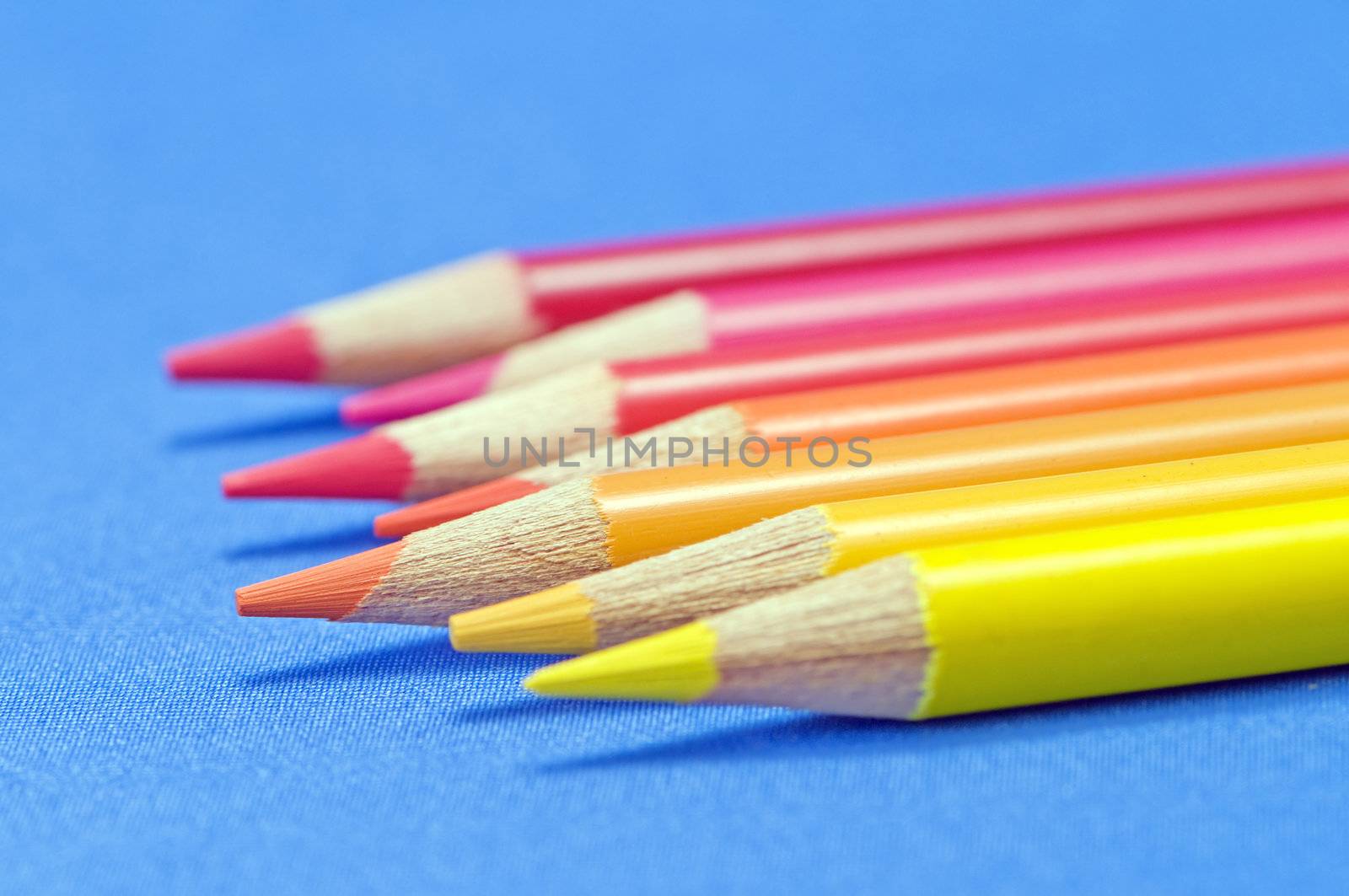 Yellow to red pencils macro on blue