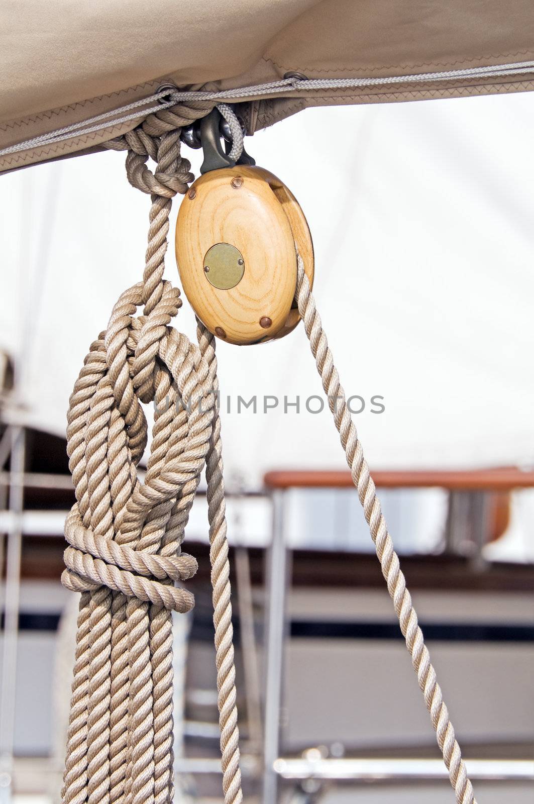 Wooden pulley with rope on a sailboat boom