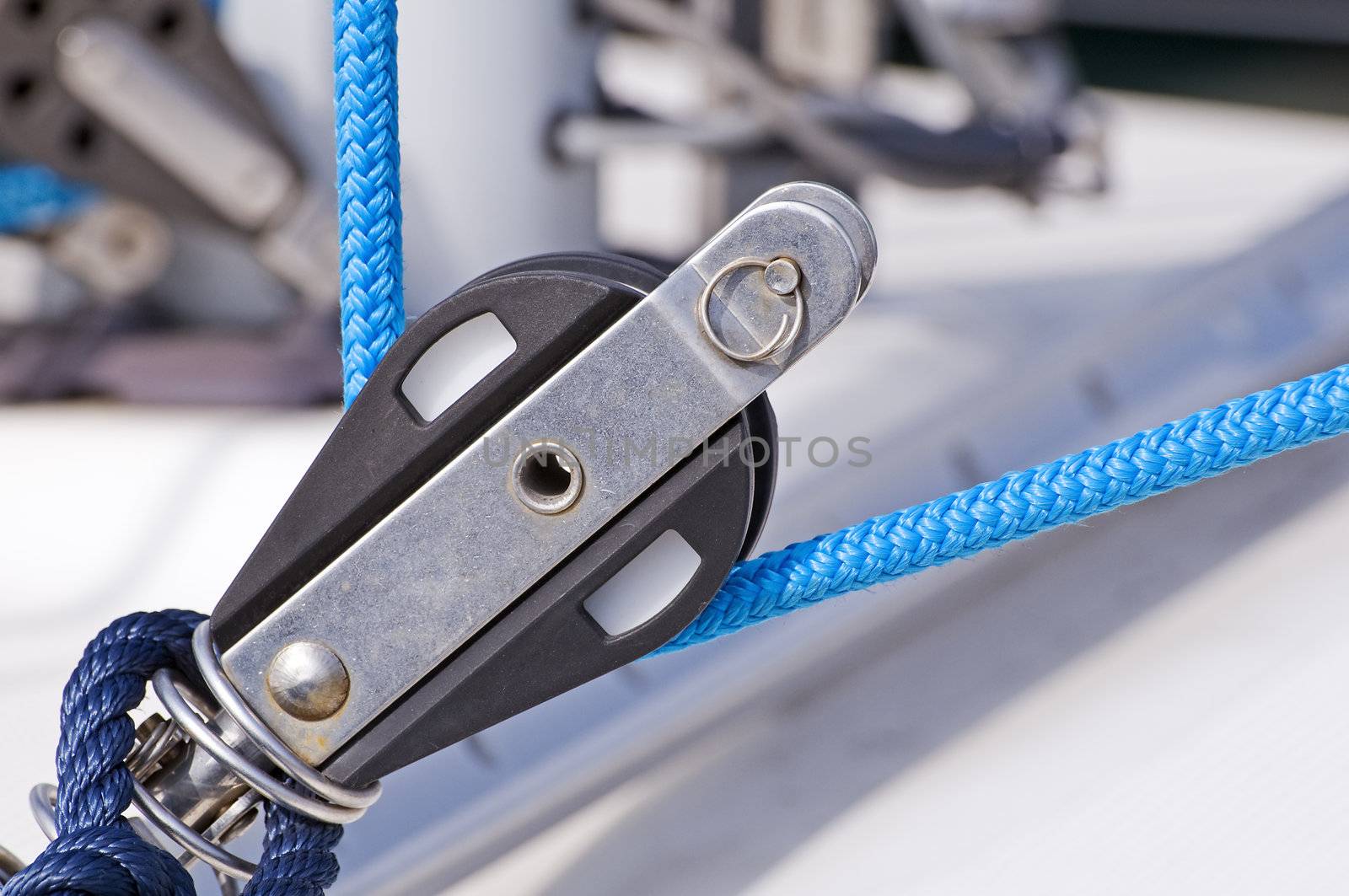 Close-up of a pulley with blue rope on a boat