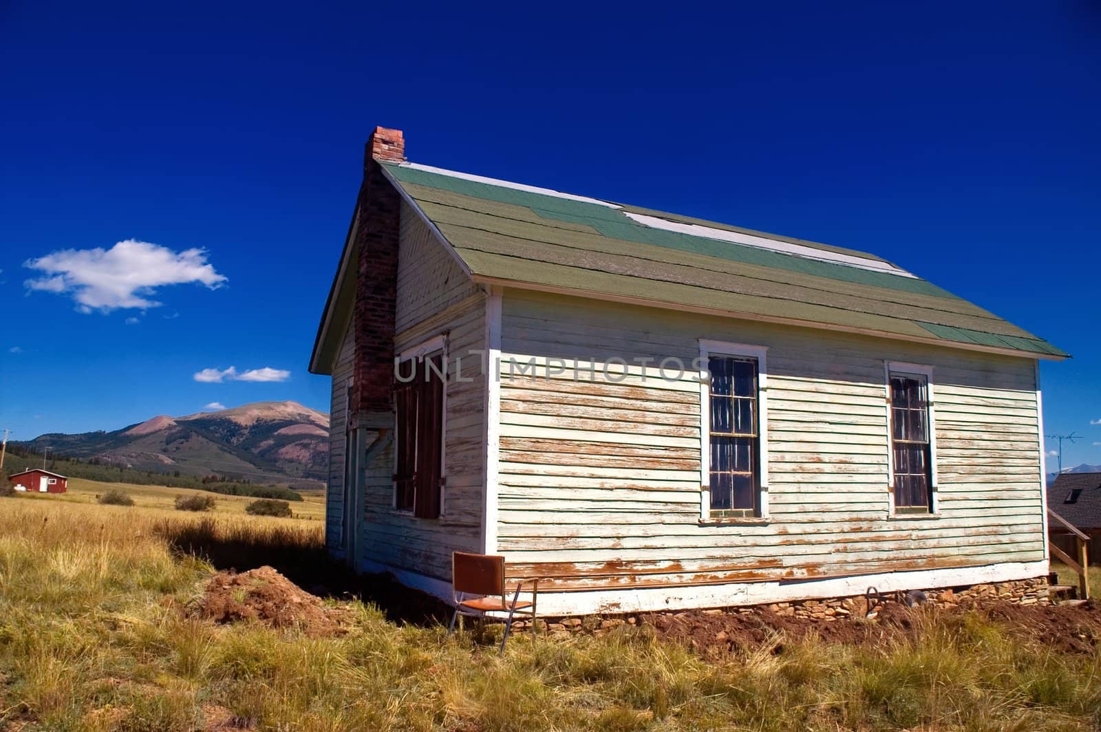 Old abandoned ghost town building in the town of Como, Colorado, stands against the backdrop of the Rocky Mountains