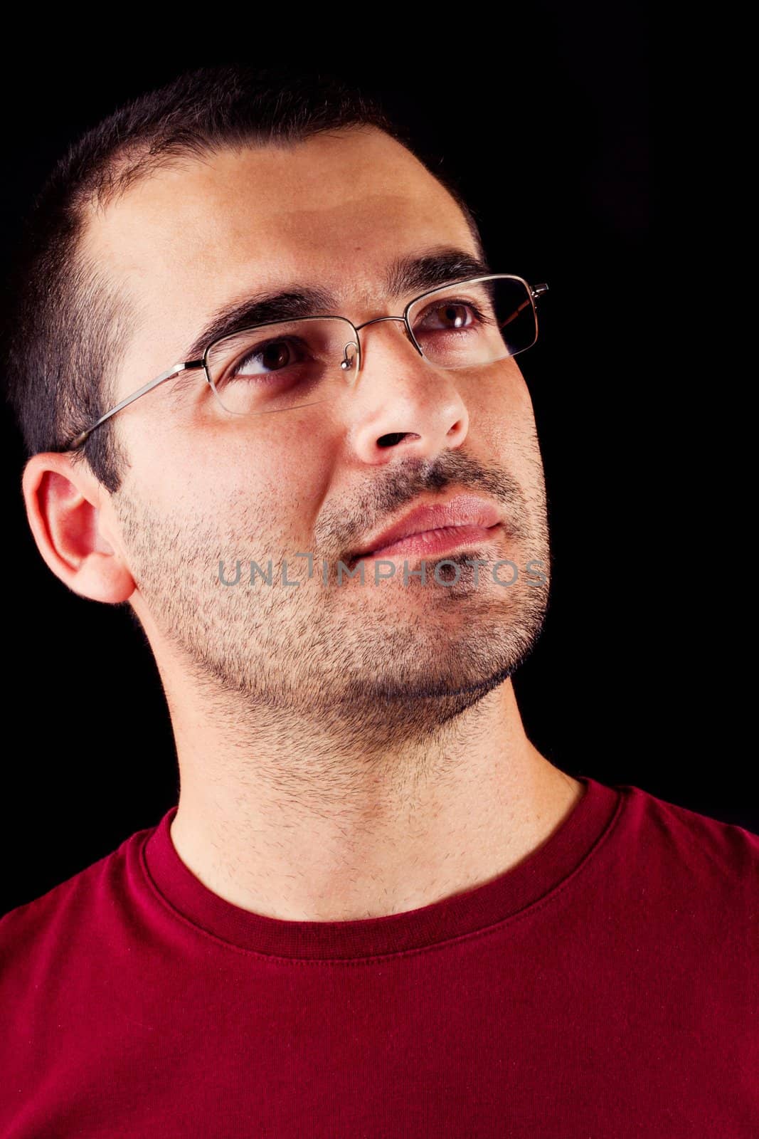 Close detail view of a thinking young  male man isolated on a black background.