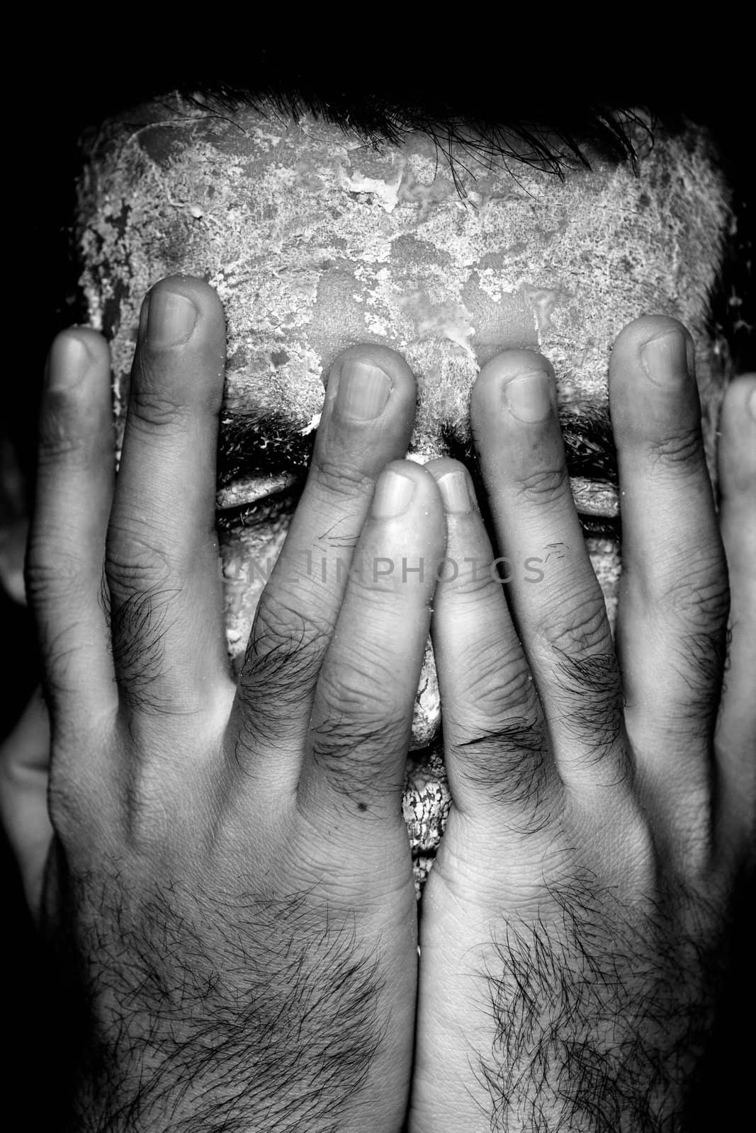 Close up view of a man's hands removing the mask from the face.