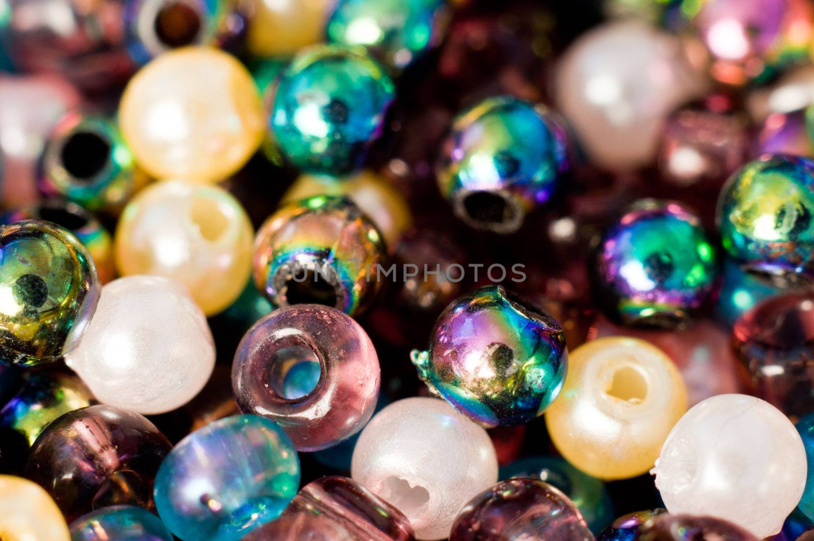 Macro photograph of tiny vibrant multi-hued plastic beads