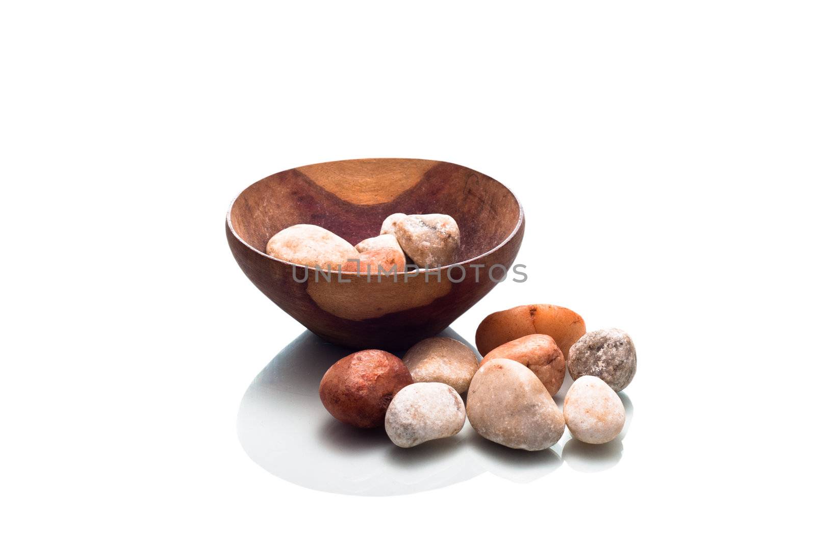Small wooden bowl containing stones isolated on a white background