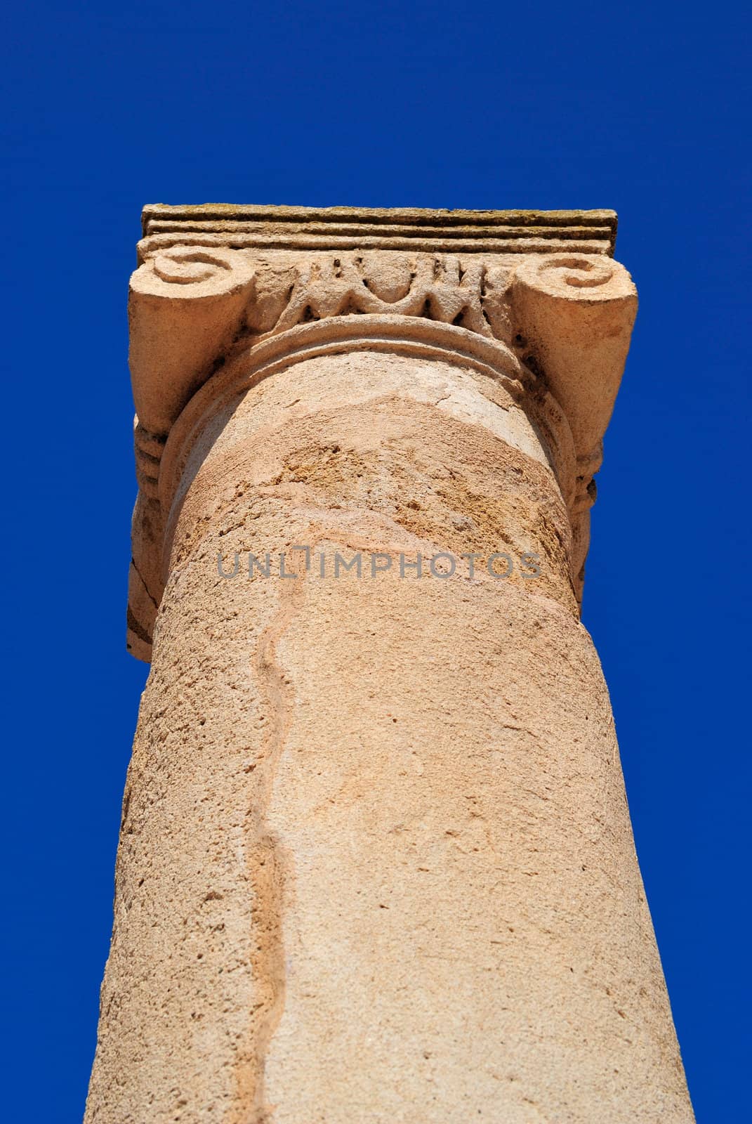 Ancient Greek columns in the ruins against a blue sky.