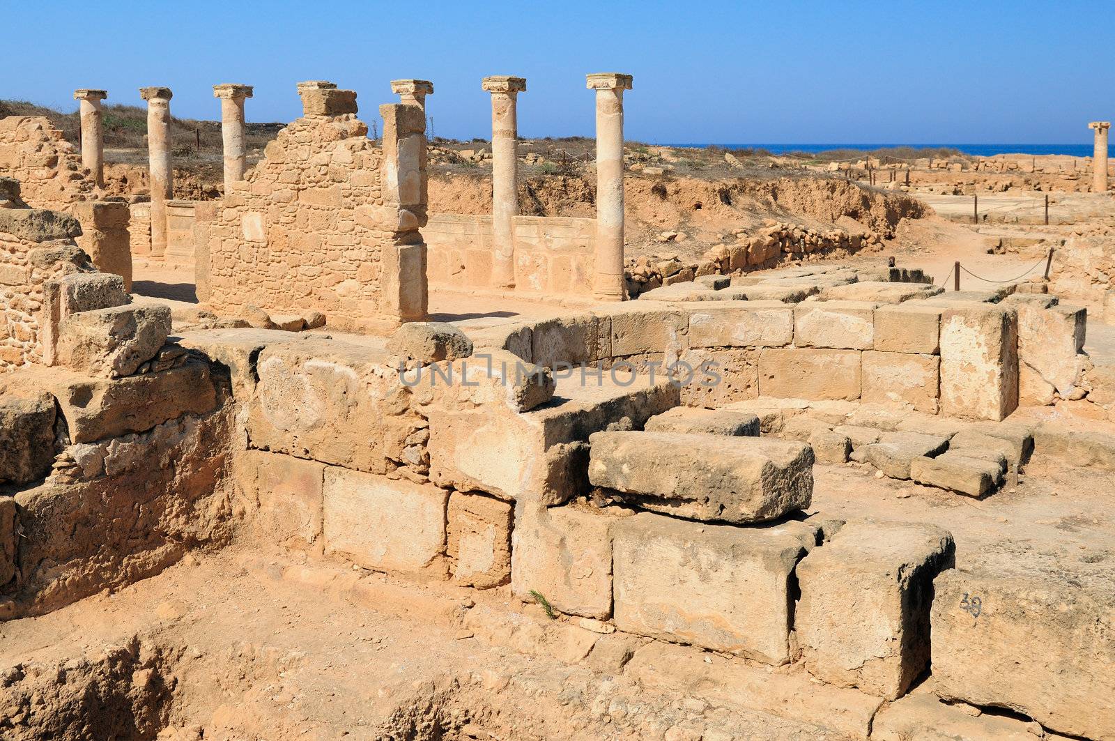 Ancient Greek columns in the ruins against a blue sky.