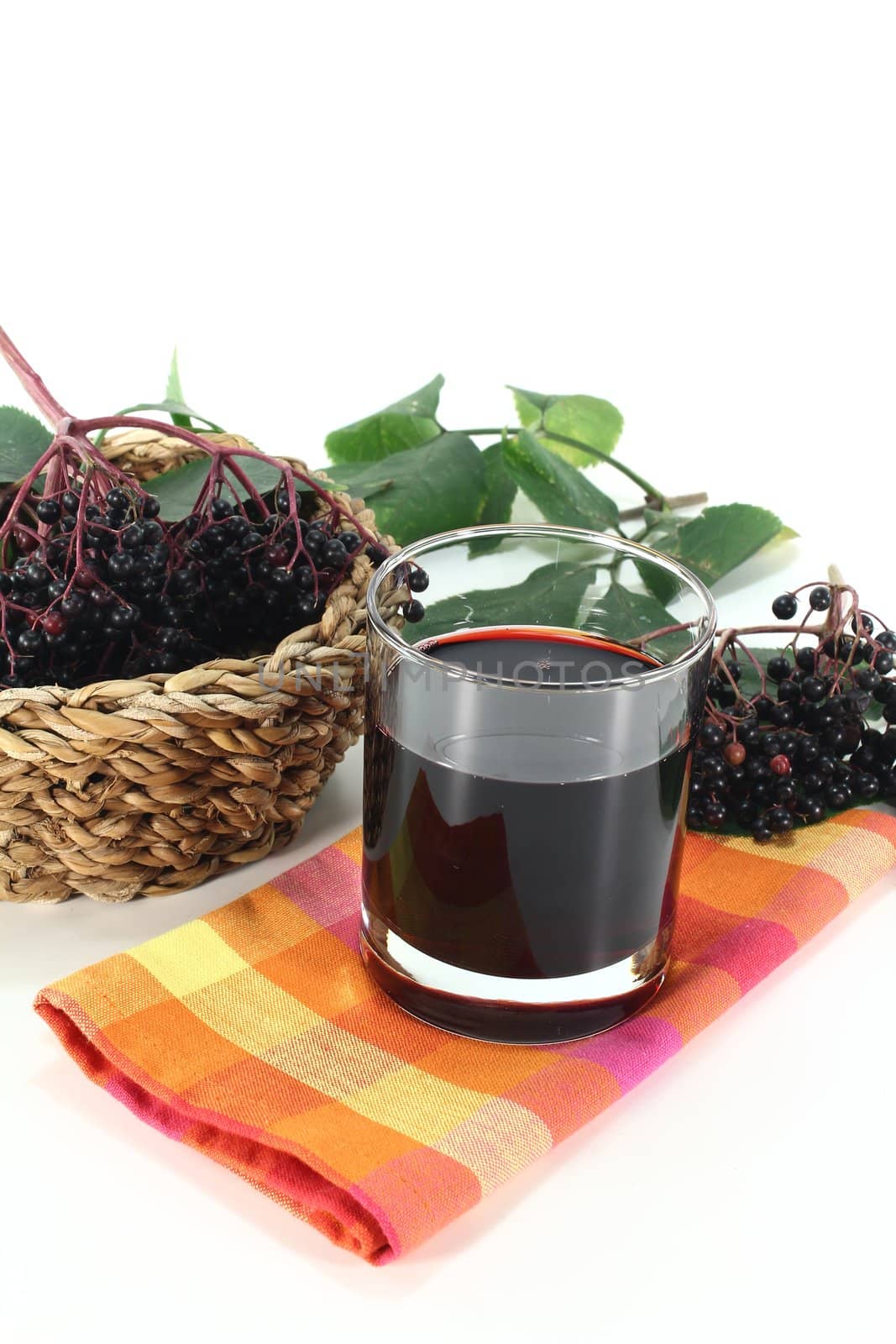 Elderberry juice with elder berries and leaves on a white background