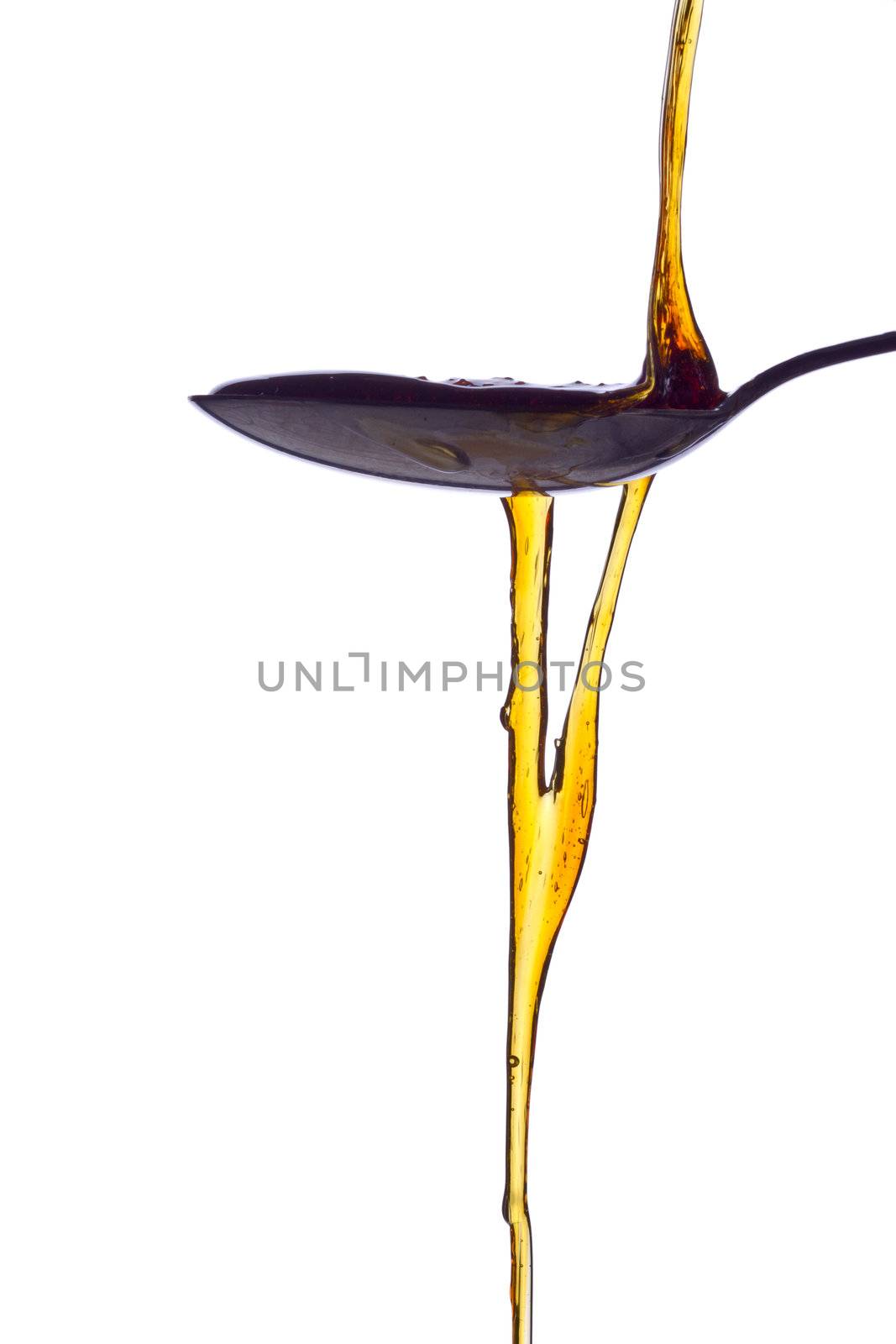 An inviting spoonful of syrup being poured out.