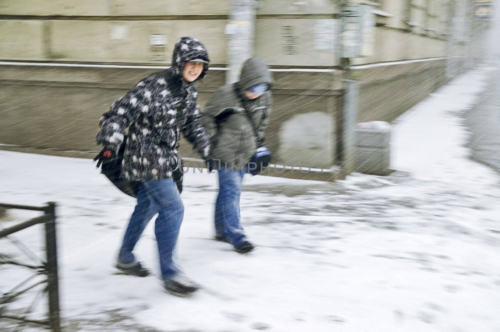 ST PETERSBURG, RUSSIA-FEBRUARY 15, 2008: Unidentified boys trying to break through heavy snowstorm and blizzard in city street