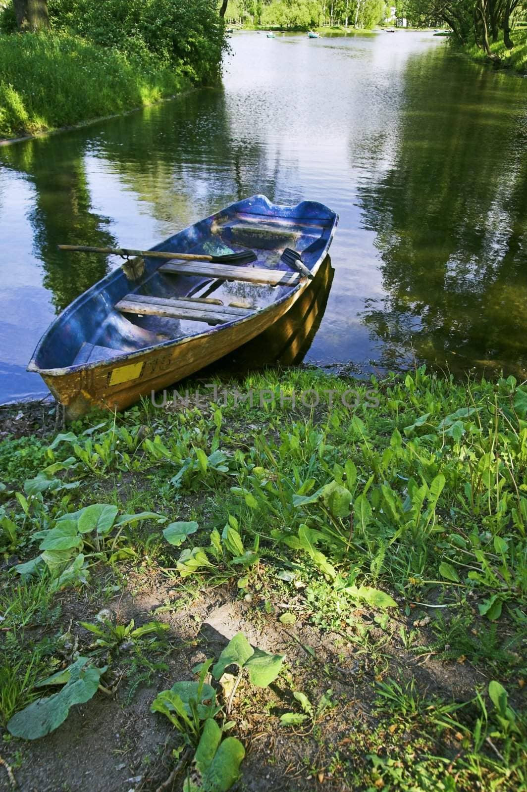 Boat at lake shore in summer park in Saint Petersburg, Russia